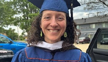 Photo of Audrey in her cap, gown, and master's hood 
