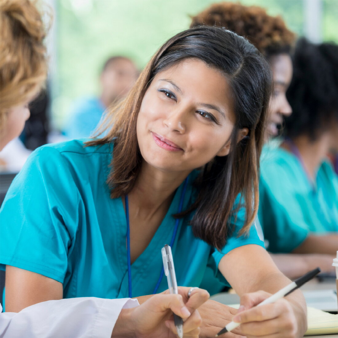 Photo of a nursing student looking at another student