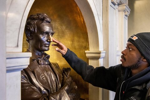 person touching Lincoln Bust's nose