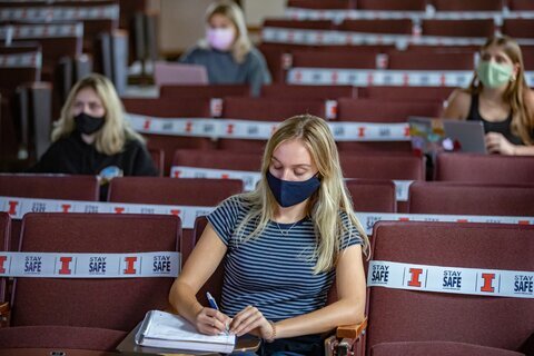 people taking notes in lecture room