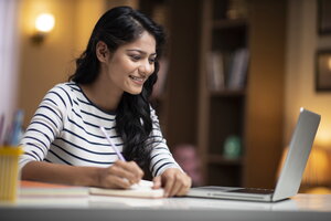 Woman sitting in front of open laptop